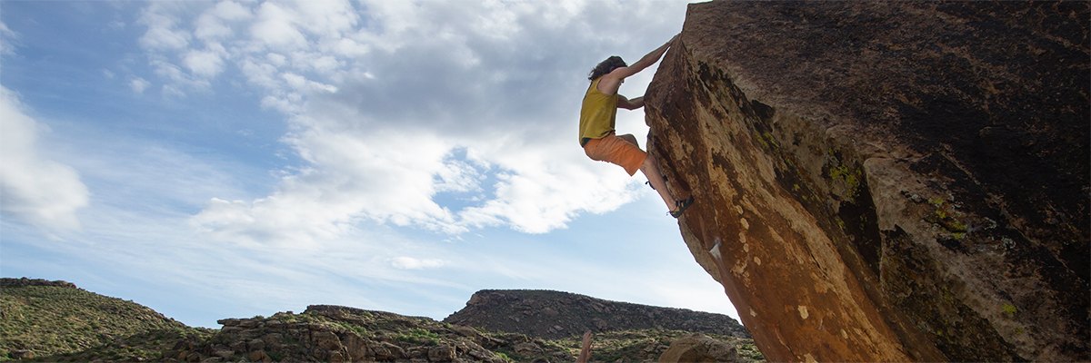 A climber high on the orange arete of Shothole in Moe's Valley